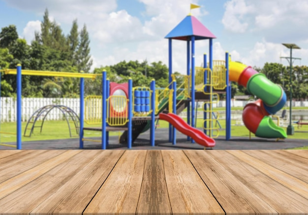 Empty wooden table with kids park on background