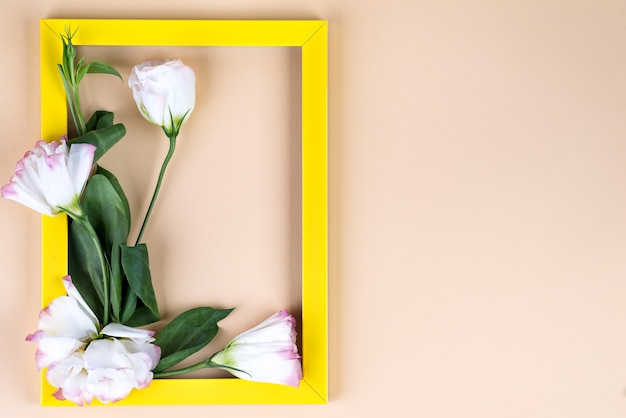 Empty yellow frame and flowers