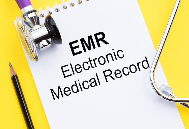 Foto emr elektronisch medisch dossier tekstconcept geschreven op kladblok met stethoscoop