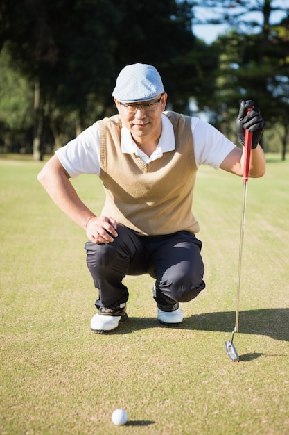 En portret die van golfspeler zijn bal buigen kijken