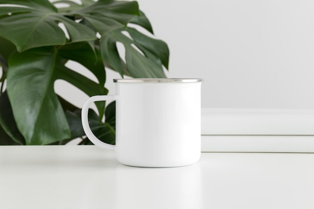 Enamel mug mockup with workspace accessories and a monstera plant