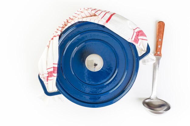 Enameled blue cast iron covered dutch oven on a white background.