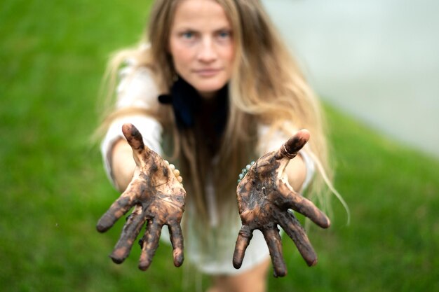 Enchantress woman portrait with dirty muddy palms