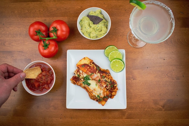 Enchiladas and margarita on wood table