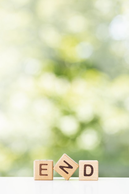 Foto la fine sul blocco di legno la fine estate sfondo verde per il tuo design