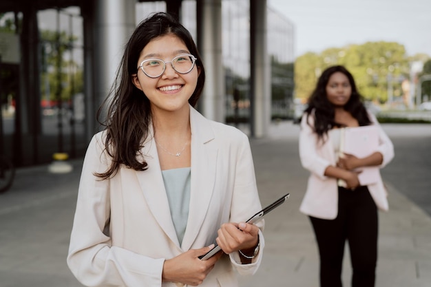 The end of work in the office coworkers go outside from company building young business people