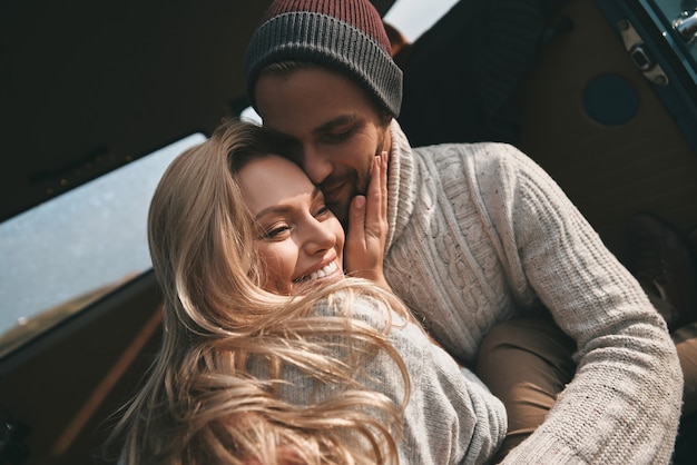 Amore infinito. bella giovane coppia sorridente mentre è seduta faccia a faccia in mini furgone in stile retrò