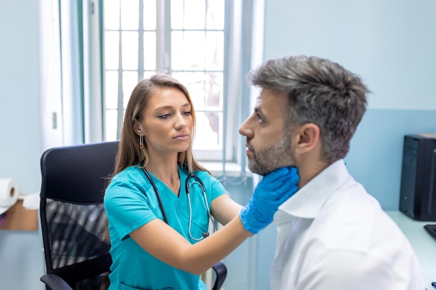 Endocrinologist examining throat of man in clinic Men with thyroid gland test Endocrinology hormones and treatment Inflammation of the sore throat