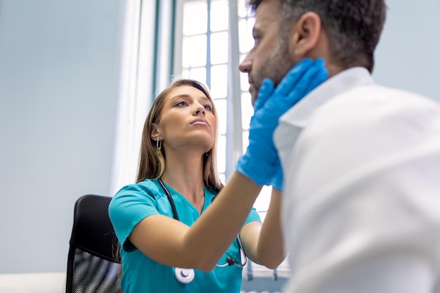 Фото Эндокринолог осматривает горло мужчины в клинике мужчины с тестом на щитовидную железу эндокринологические гормоны и лечение воспаление ангины