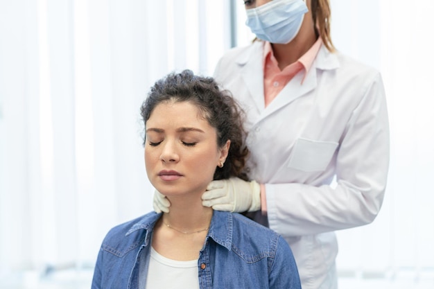 Endocrinologist examining throat of young woman in clinic Women with thyroid gland test Endocrinology hormones and treatment Inflammation of the sore throat