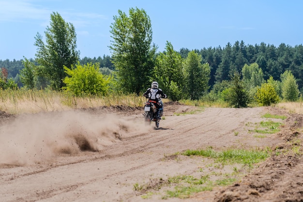 An Enduro bike racer riding on a dirt motocross road