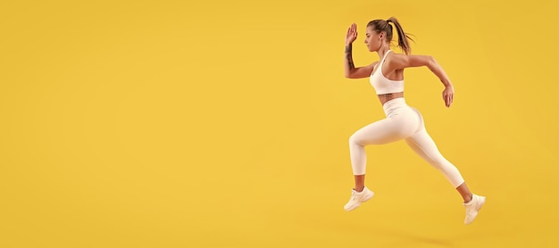 Energetic fitness woman runner running on yellow background Woman jumping running banner