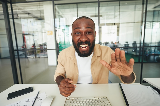 Energetic man smiling and waving at the camera