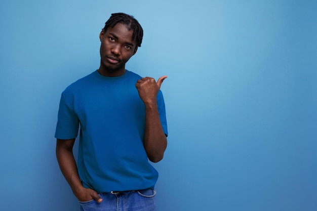 Energetic young black american man pointing at wall over isolated background