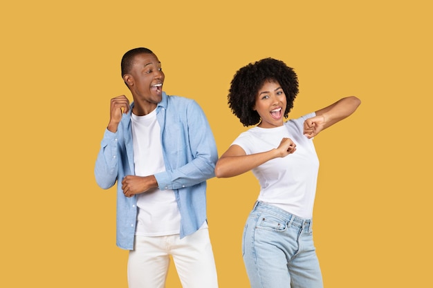 Energetic young couple playfully dancing and pointing full of joy and excitement