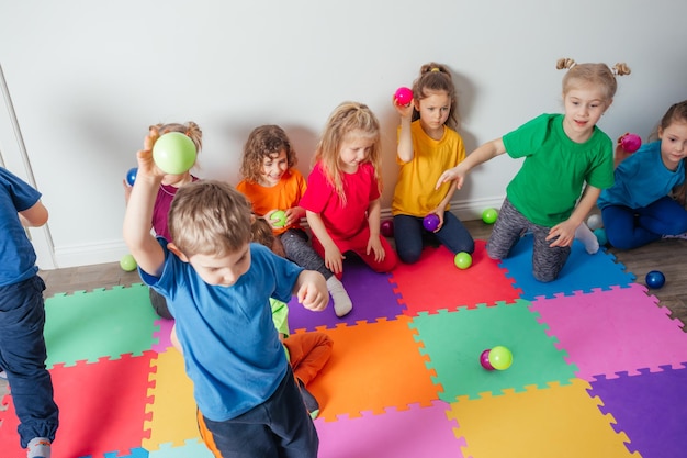 Energetic youngsters throwing away many colorful balls