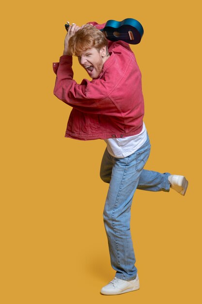 Foto energie. man in rood jasje met ukelele opgewonden gevoel