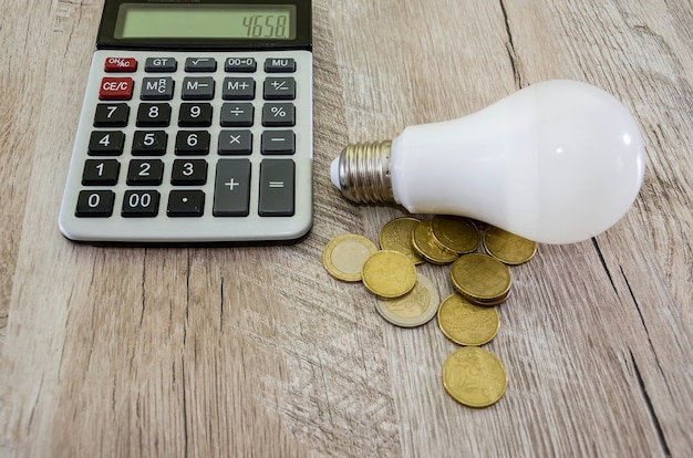 Energiebesparend concept Een gloeilamp met een rekenmachine en geld