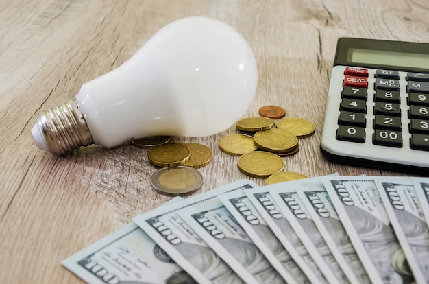 Energiebesparend concept Een gloeilamp met een rekenmachine en geld