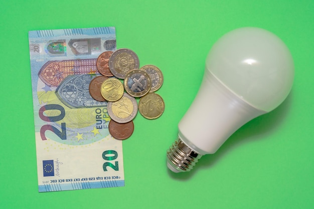 Energiebesparende lamp met contant geld en munten geld Besparingen