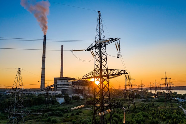 Energiedistributienetwerk elektriciteitspylonen tegen oranje en gele zonsondergang selectieve focus