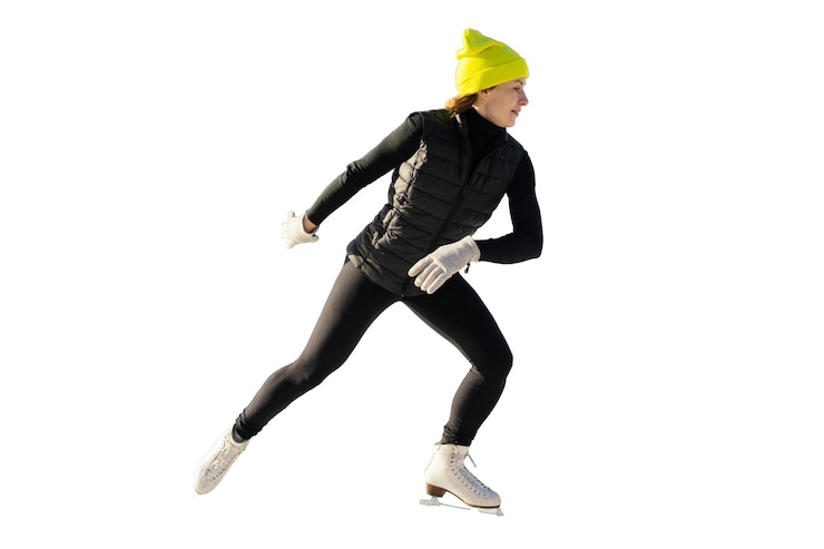 Foto energische kunstschaatser in zwarte kleding en gele pet in actie op het ijs gevangen in een dynamische