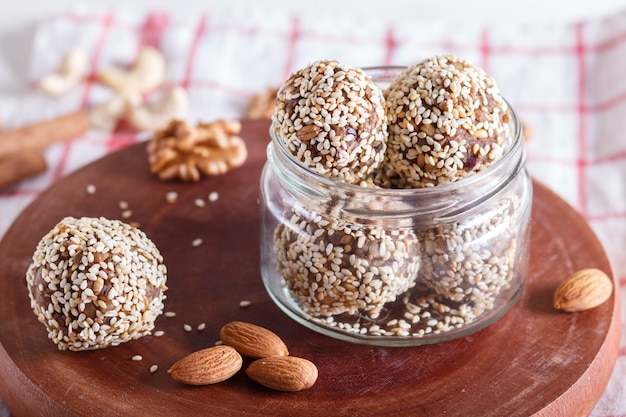 Energy balls cakes with almonds sesame cashew walnuts dates and germinated wheat in glass jar  close up