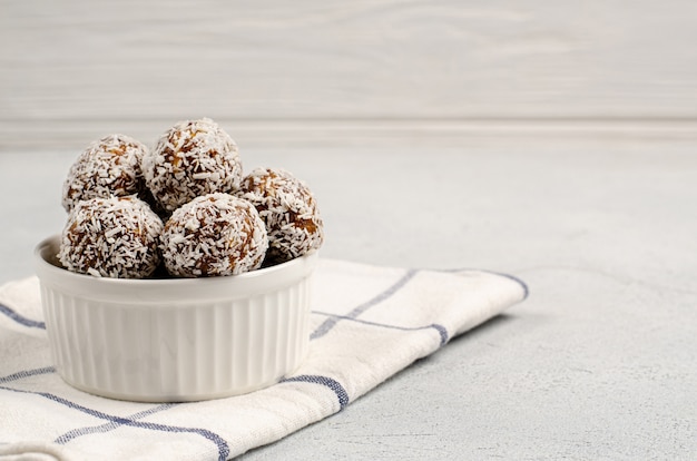 Energy balls of dates, nuts, oats, sprinkled with coconut powder closeup