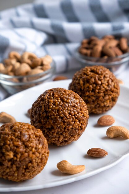 Energy bar nut balls cookie on white plate with almond and cashew Recipe of simple homemade cookie with nuts full of protein and fats Ketogenic diet or paleo diet dessert