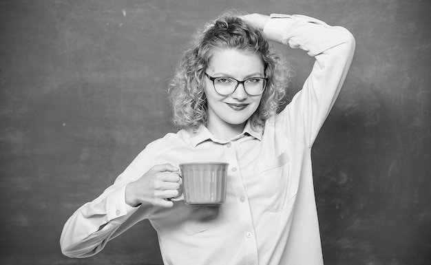 Foto carica di energia per l'intera giornata insegnante occhiali da vista bere caffè sfondo lavagna donna gustare un caffè prima delle lezioni sorseggiare ricarica corpo e mente dose di caffeina ritorno a scuola coffee addicted