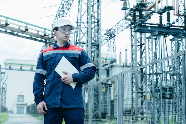 An energy engineer inspects the modern equipment of an\
electrical substation before commissioning energy and industry\
scheduled repair of electrical equipment