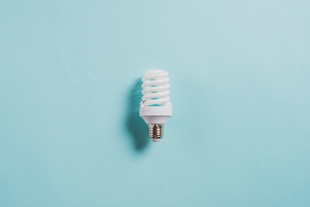 Photo energy saving compact fluorescent light bulb on blue background