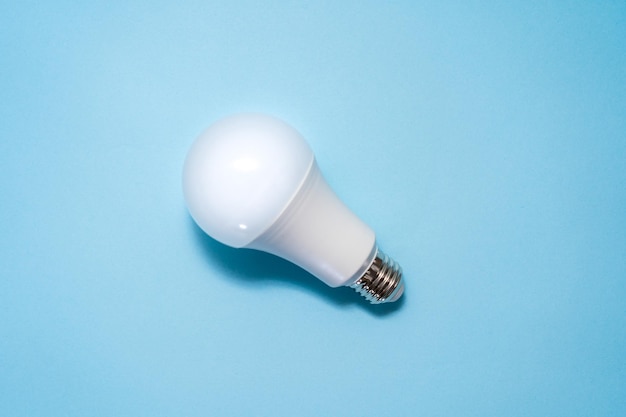 Energy saving light bulb on blue background Savings