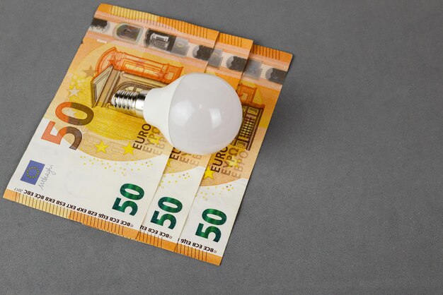 Photo energy saving light bulb and euro banknotes energy saving and savings concept