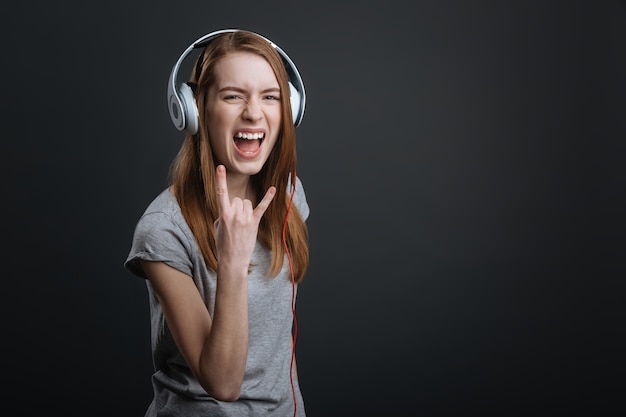 Energy of the sound. Creative artistic lovely lady testing recently bought device for listening to her music and looking emotional