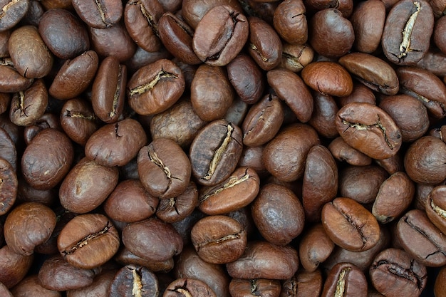 Energy stimulant and smooth java concept with full frame photograph of piled roasting coffee beans backgrounds