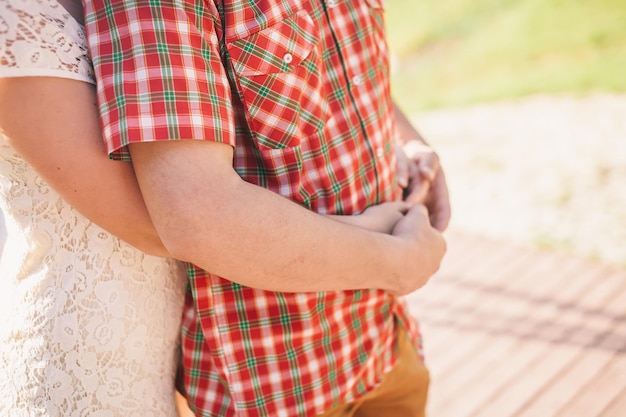 Engaged couple hug together. Close up shot of hands