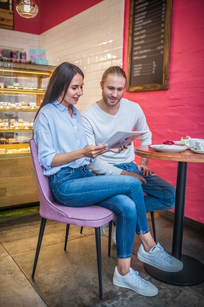 Engaged couple with wedding invitations in a cafe