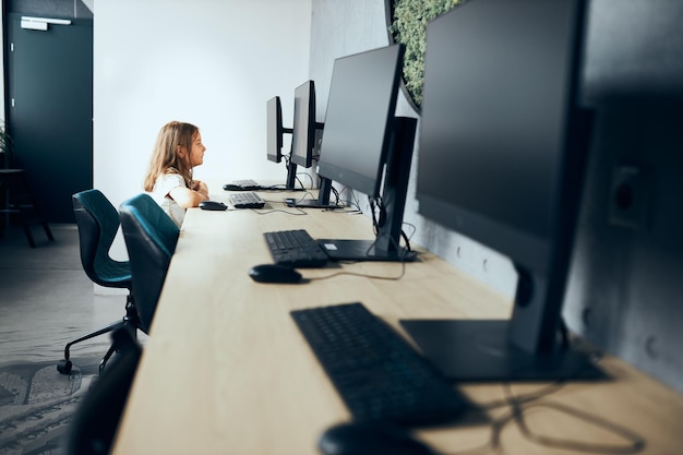 Foto studente impegnata che impara con il computer in classe a scuola elementare bambino che utilizza la tecnologia