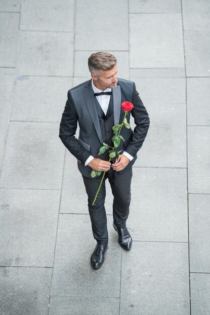 Engagement date handsome tuxedo man celebrates engagement man with rose gift for engagement