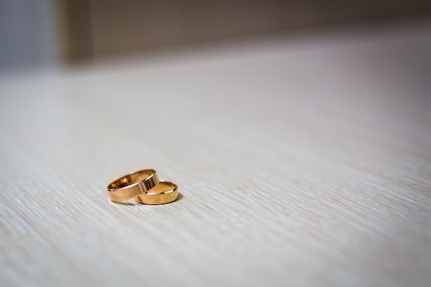 Engagement gold rings on each other lie on a light surface