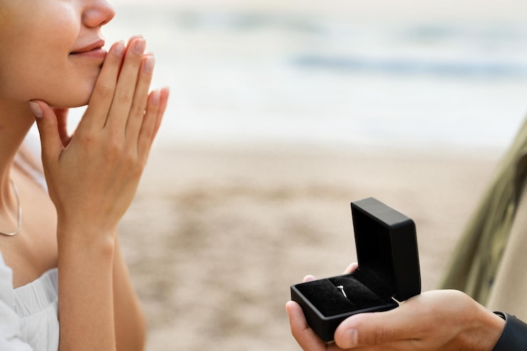 Photo 婚約男性がガール フレンドに結婚の質問をし、ビーチのクローズ アップで彼との結婚を提案しています