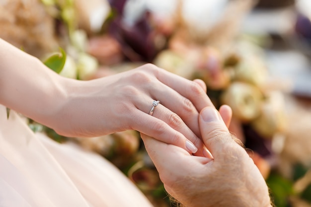 Sposi novelli di fidanzamento. fede nuziale sulla mano della sposa.