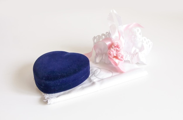 Photo engagement ring box on white background and a garter from the bride's stocking