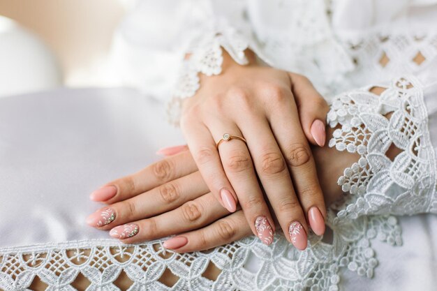 Фото Обручальное кольцо на пальце невесты красивое кружево на платье