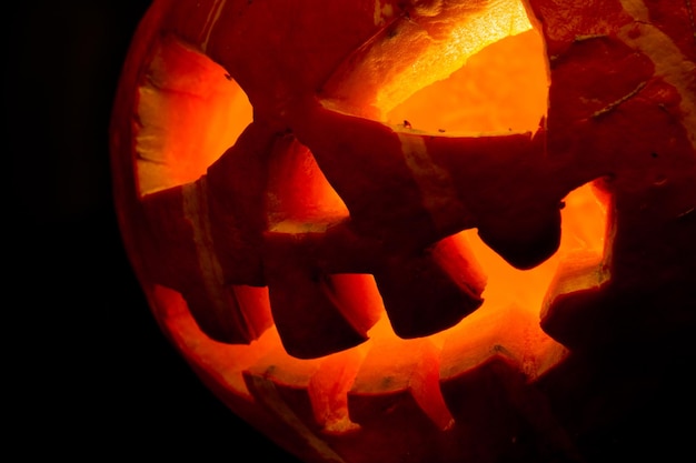 Enge oude jack-o-lantern op zwarte achtergrond.