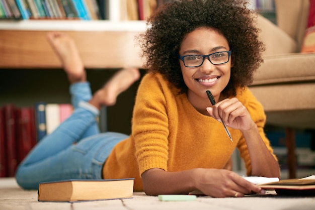 Engels is mijn favoriete onderwerp Volledig portret van een jonge vrouw die tijdens het studeren op de grond ligt