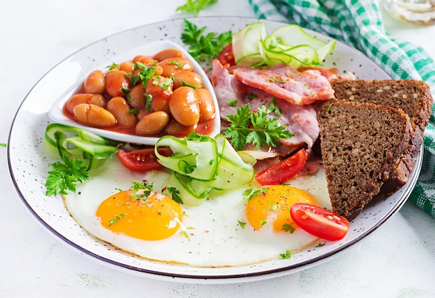 Engels ontbijt - gebakken ei, bonen, spek, tomaten en brood.