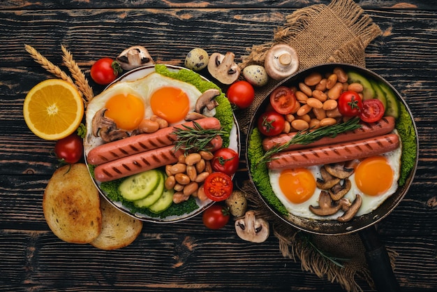 Engels ontbijt gebakken ei bonen tomaten champignons spek en toast Bovenaanzicht op een houten achtergrond