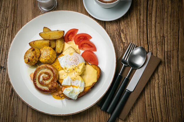 Engels ontbijt met toast, gepocheerd ei, saus en worst op een houten tafel